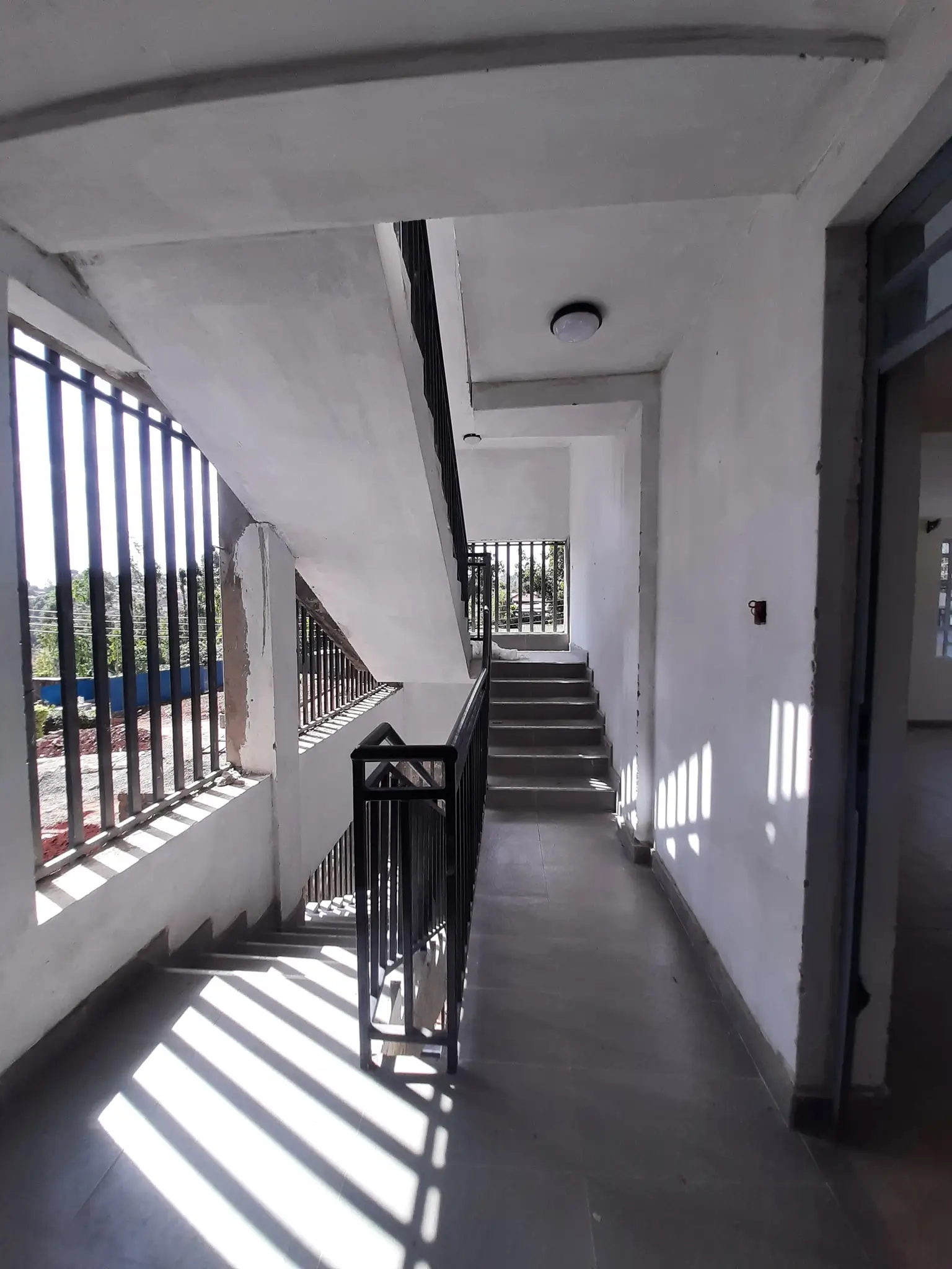 Bright corridor with staircase and metal railing