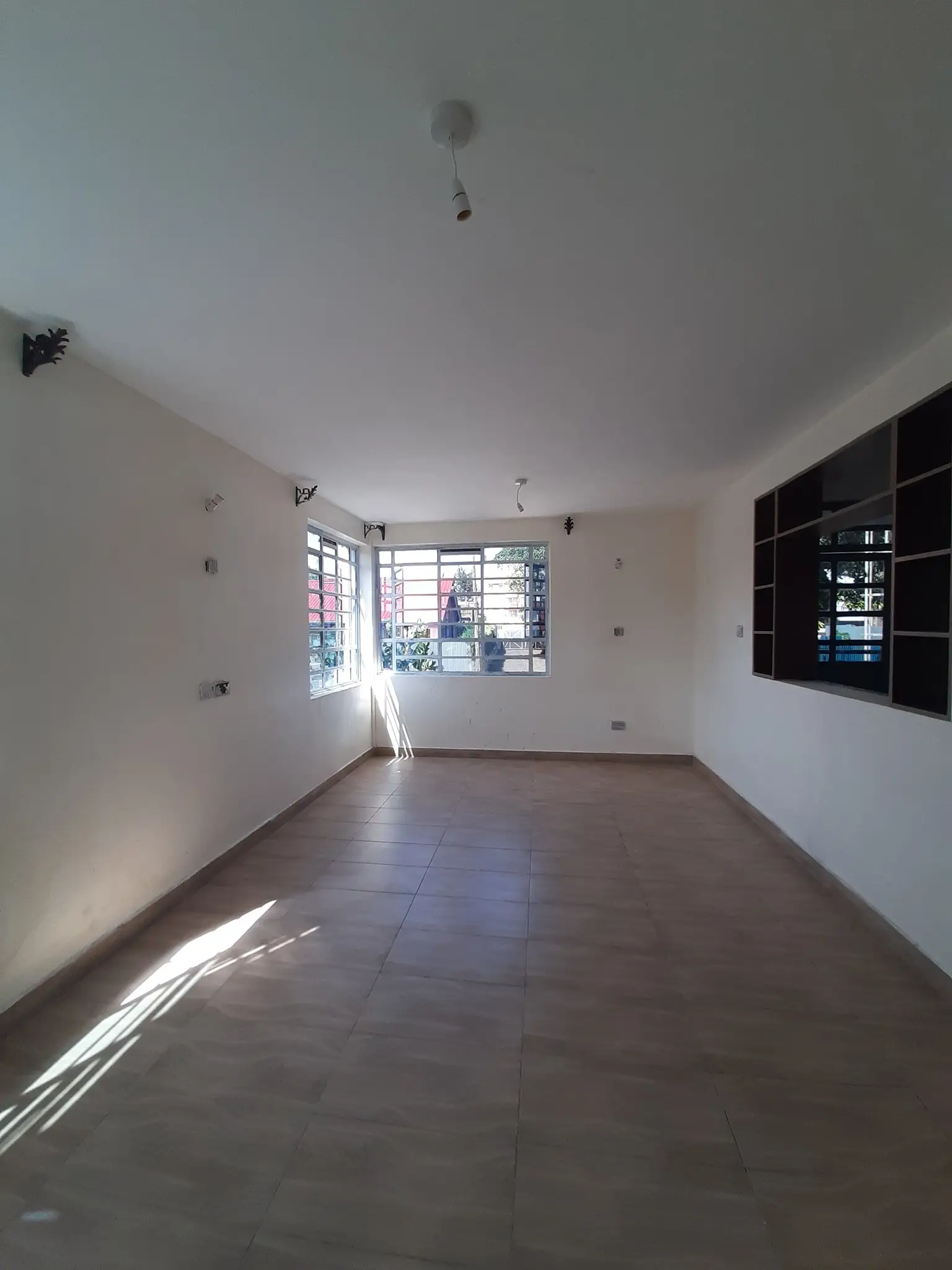 Spacious living room with tiled floors and built-in shelving