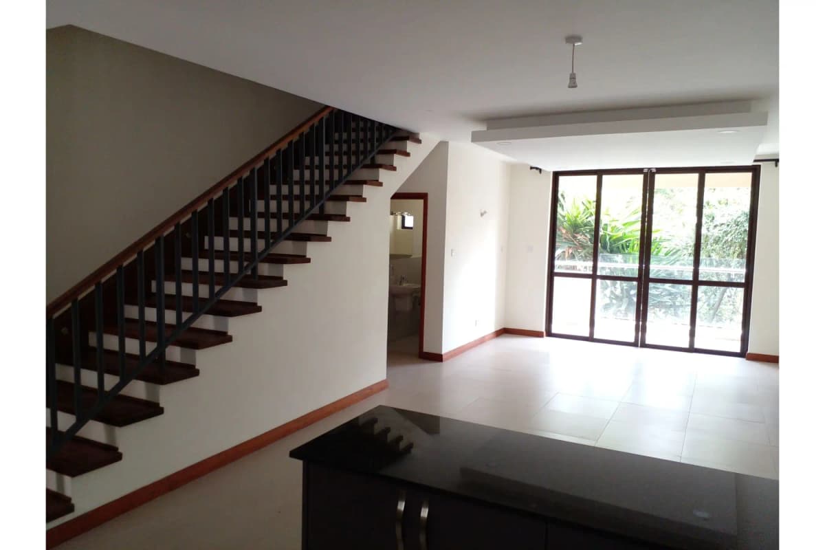 Open-plan lobby and living area with wooden staircase and garden views