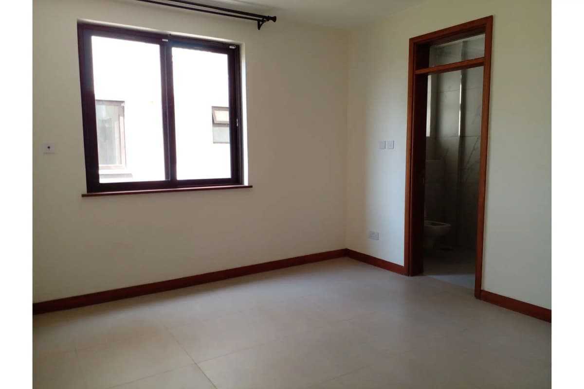 Empty bedroom with large windows and wooden door frame