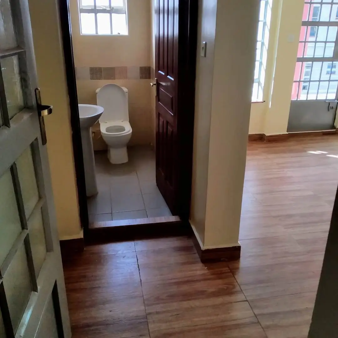 Compact bathroom with white toilet and tiled flooring