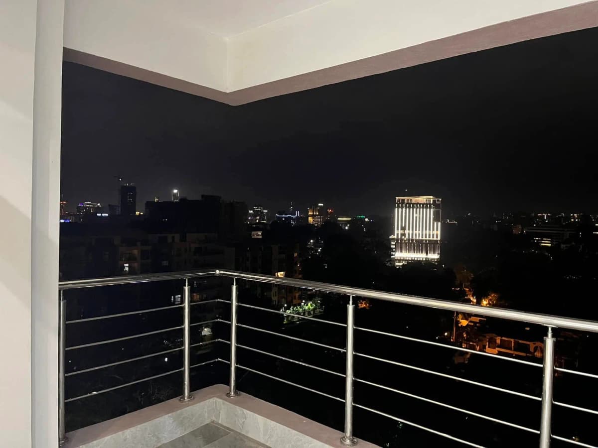 Corner balcony with city skyline views at night