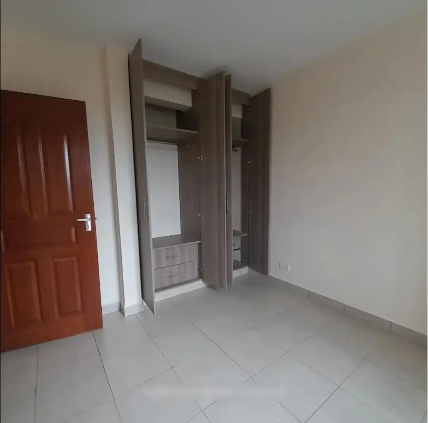 Spacious bedroom with built-in wardrobe and tiled flooring