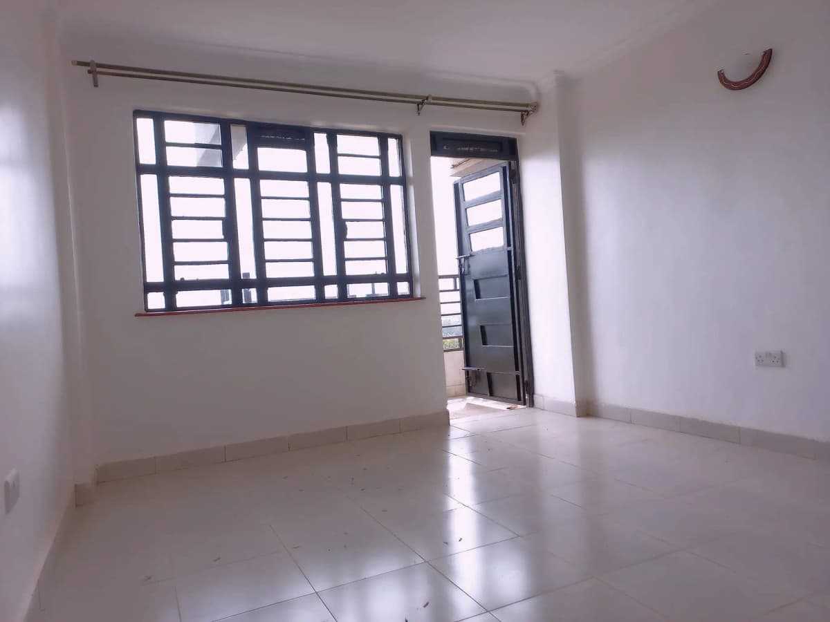 Bright empty living room with louvered windows and tiled flooring