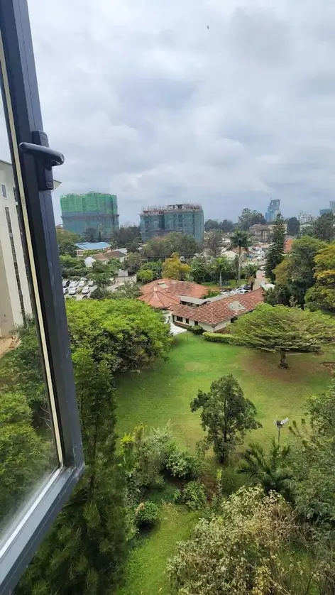Elevated view of lush green compound with modern city skyline
