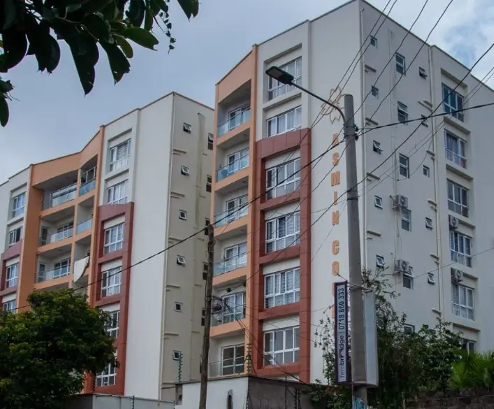Multi-story residential apartment building with orange and cream facade