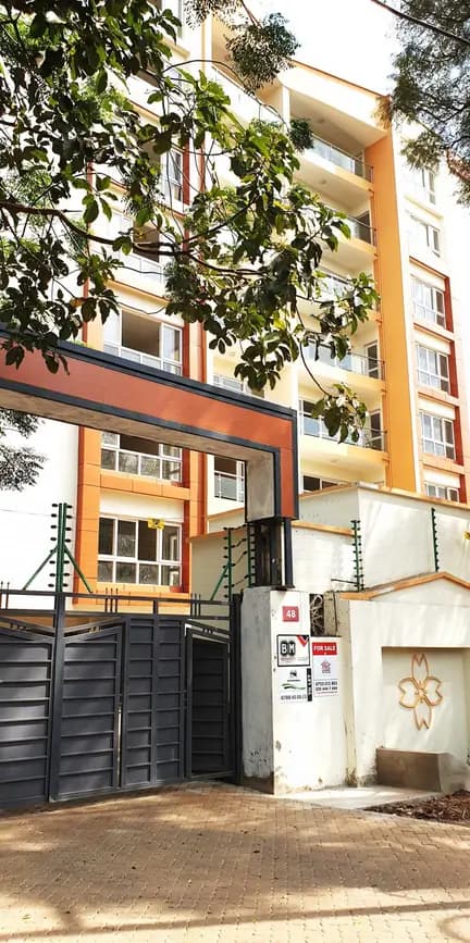 Modern apartment building facade with gated entrance and driveway