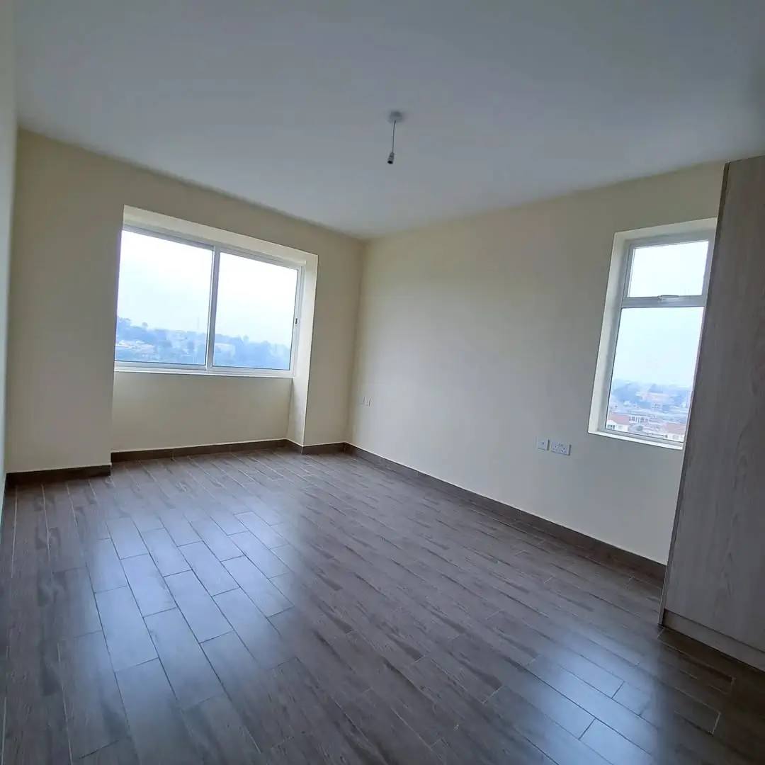 Spacious bedroom with dual windows and city views