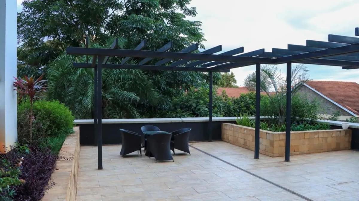 Covered terrace with pergola, dining table, lush greenery