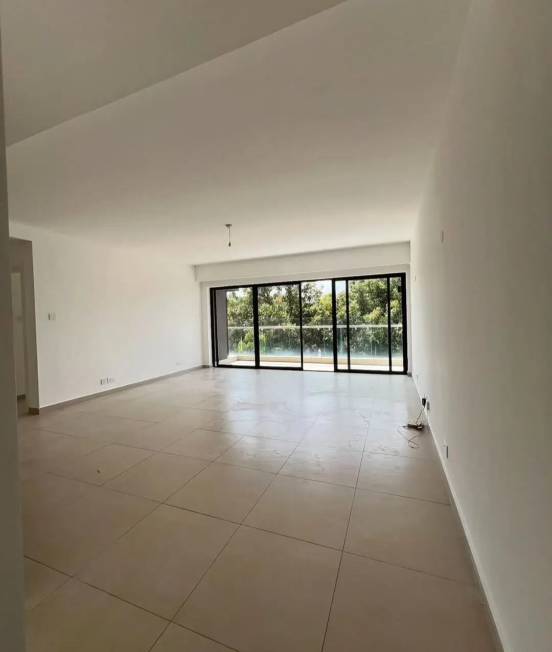 Spacious open-plan living room with large glass sliding doors