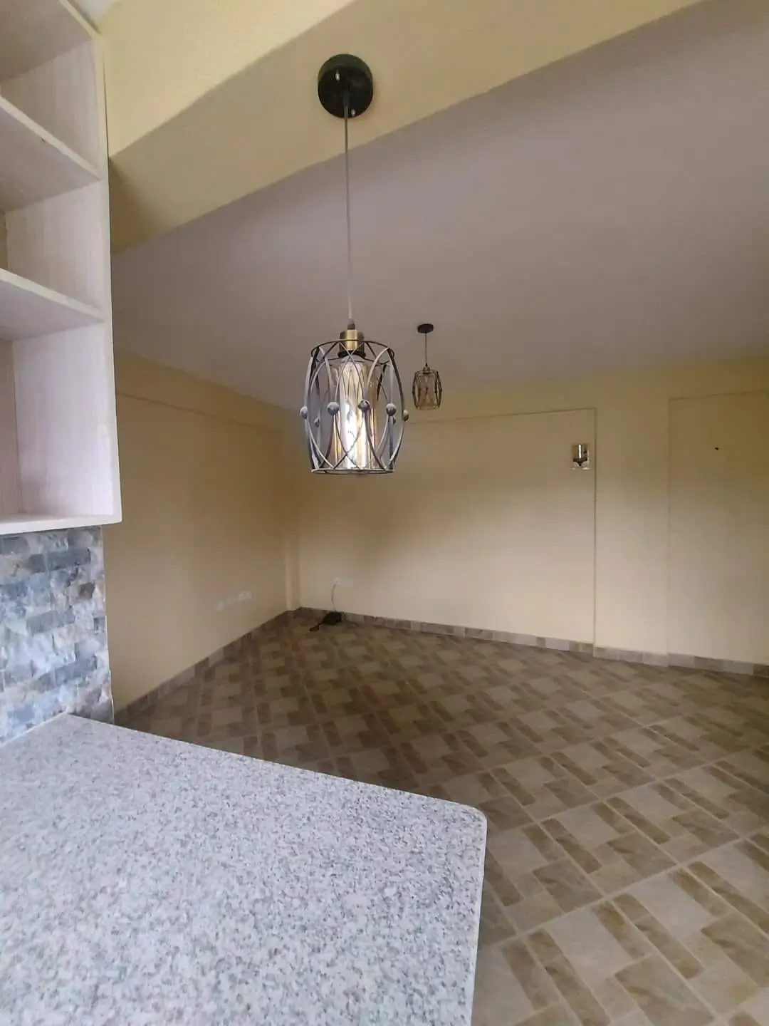 Open-plan kitchen with white countertop and pendant lighting