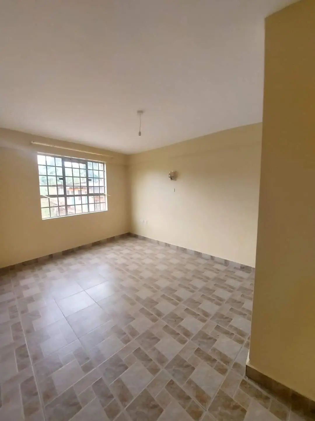 Unfurnished bedroom with brick-pattern flooring and natural light