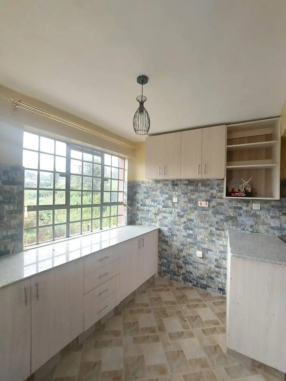 Modern kitchen with mosaic backsplash and large window