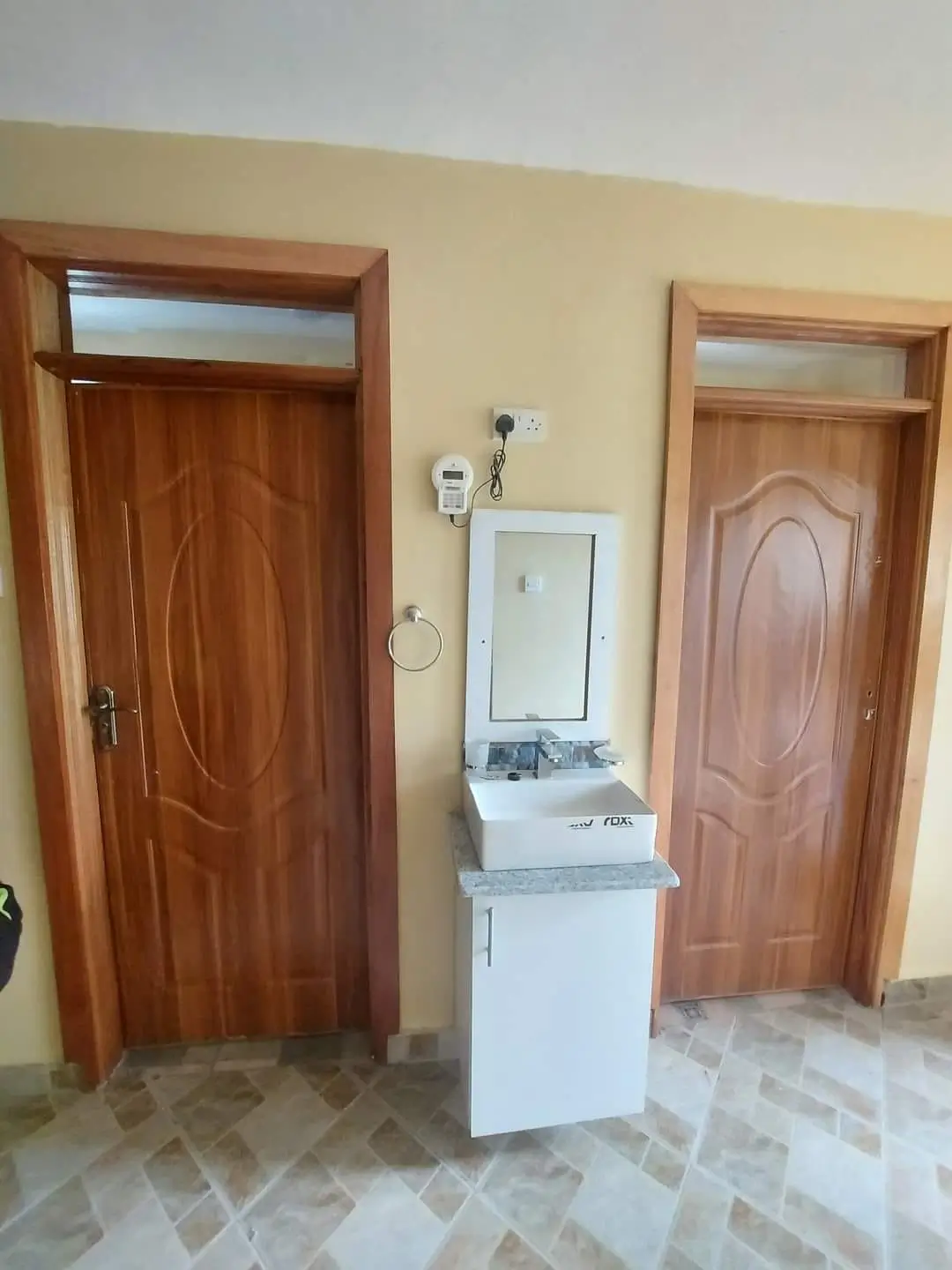 Compact bathroom with white pedestal sink and wooden doors