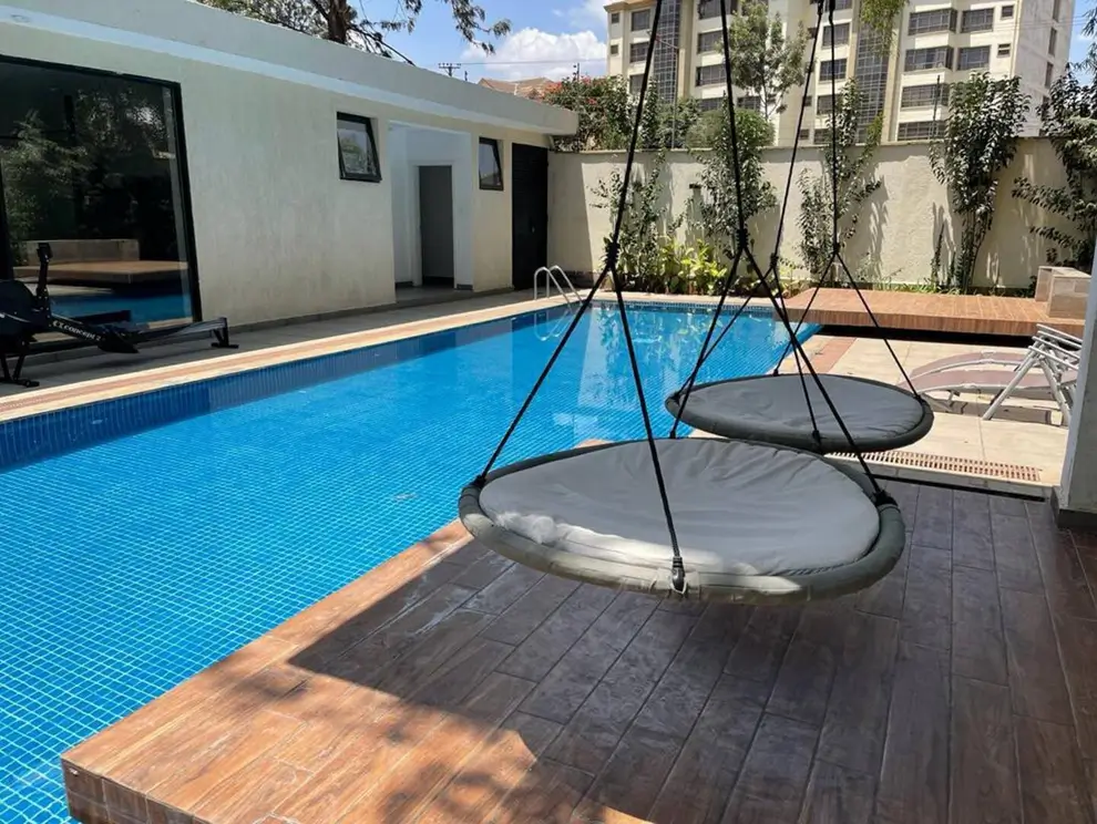 Residential swimming pool with wooden deck and lounging area