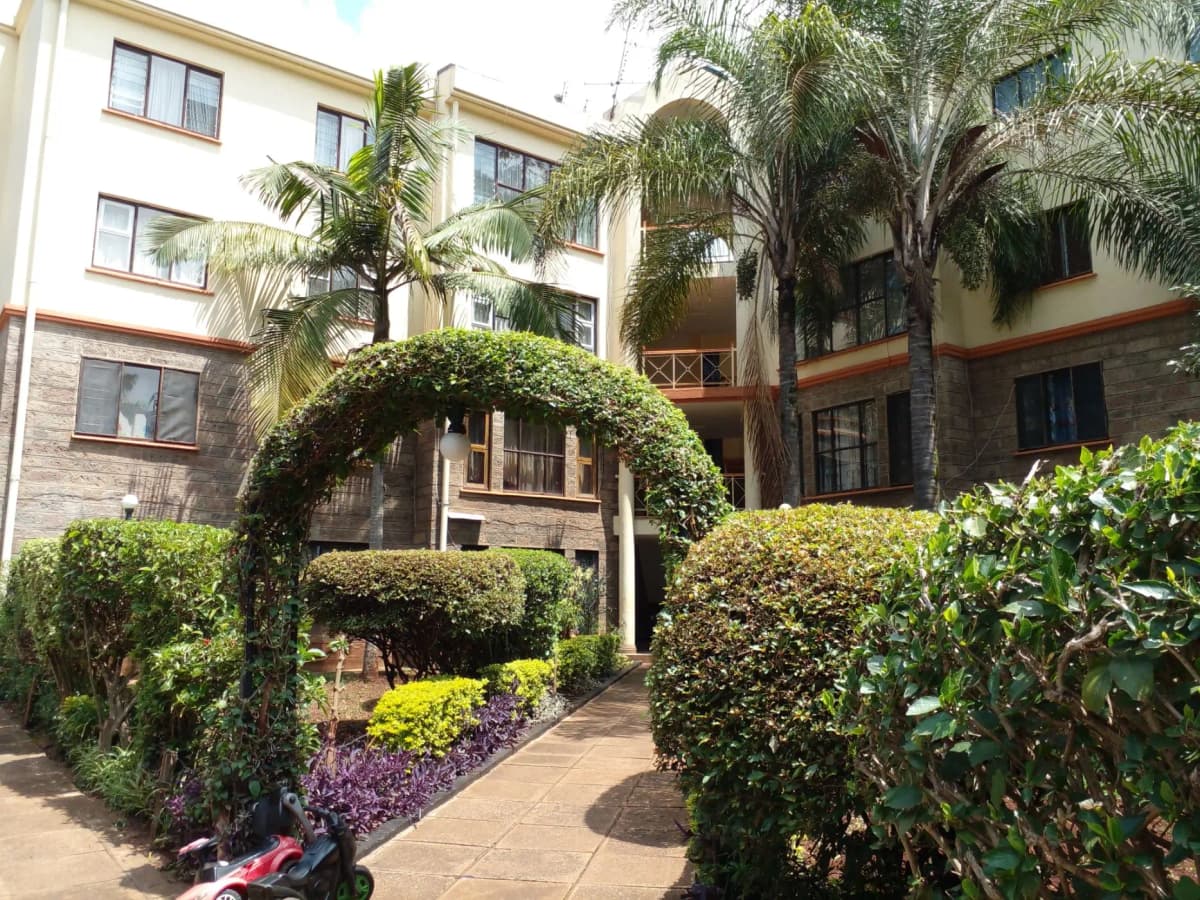 Manicured compound grounds with topiary, palm trees, flowering shrubs