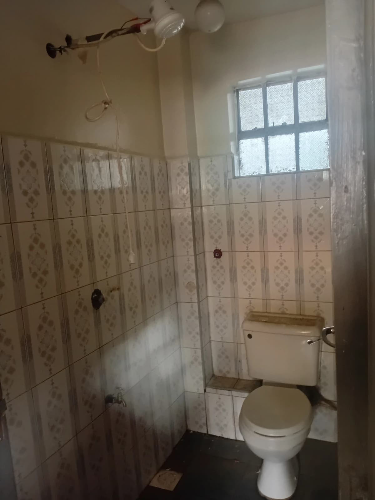 Basic bathroom with toilet, sink, and tiled shower enclosure