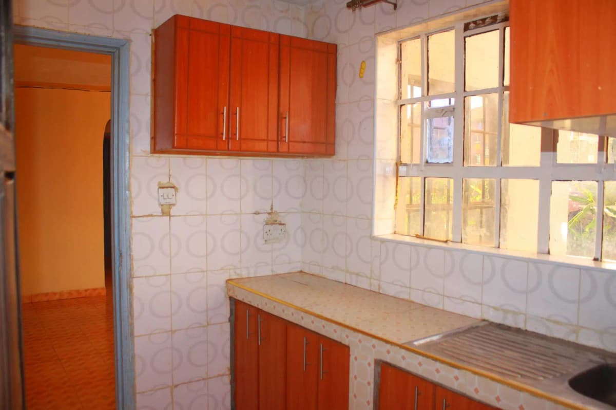 Compact kitchen with red cabinetry and tiled walls
