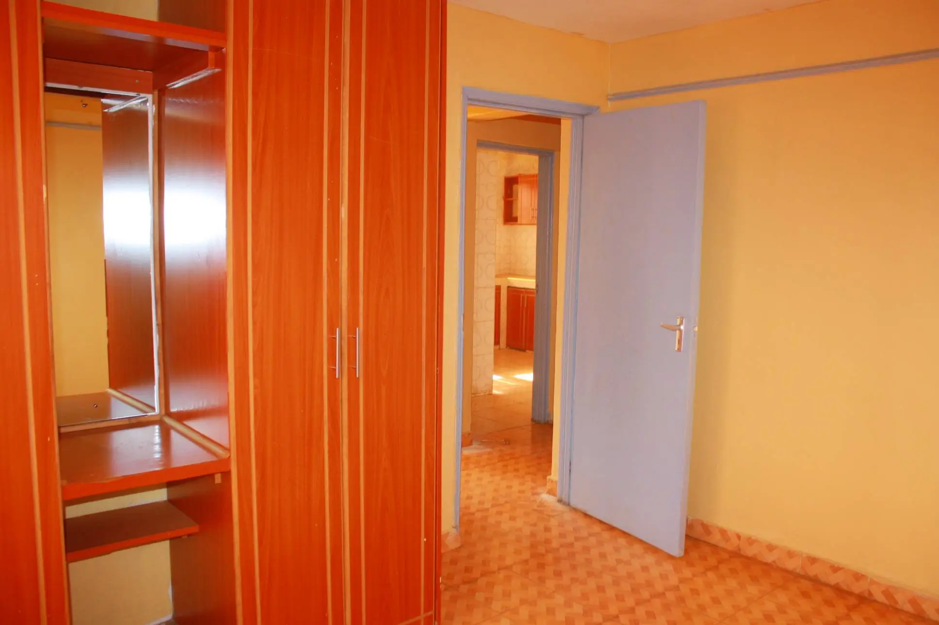 Building corridor with orange wardrobe and multiple doorways