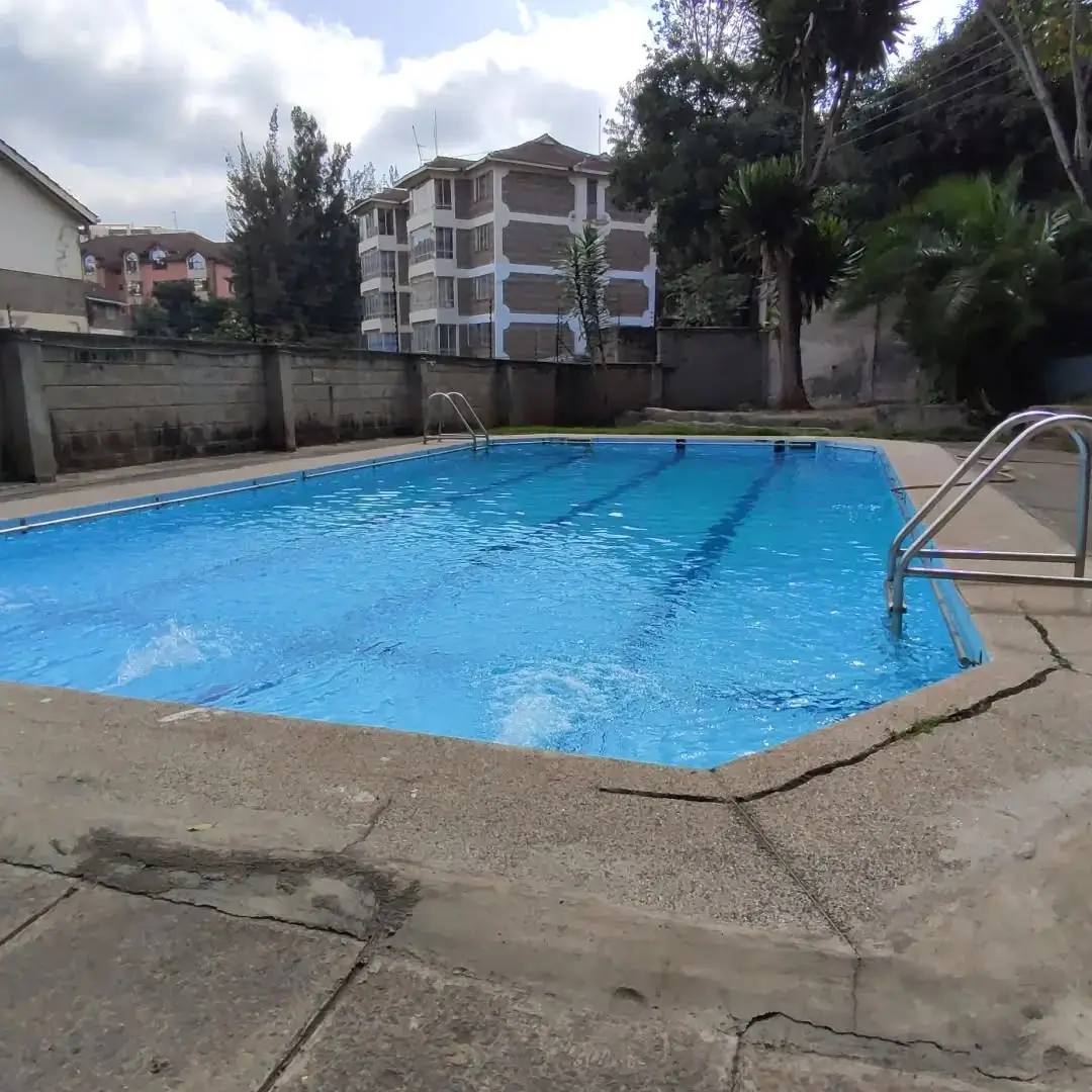 Residential swimming pool with concrete deck and metal railing