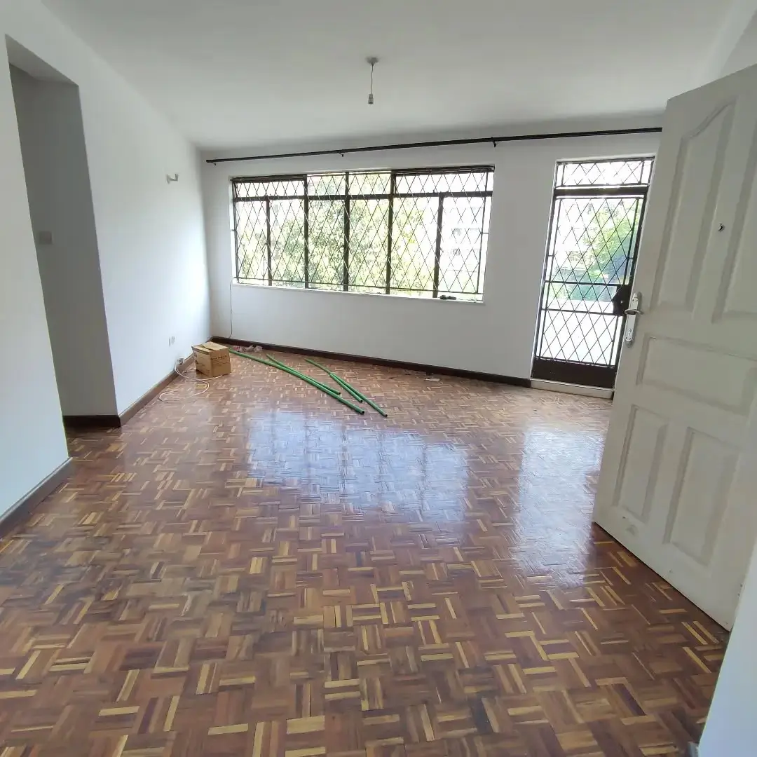 Spacious living room with parquet flooring and large windows