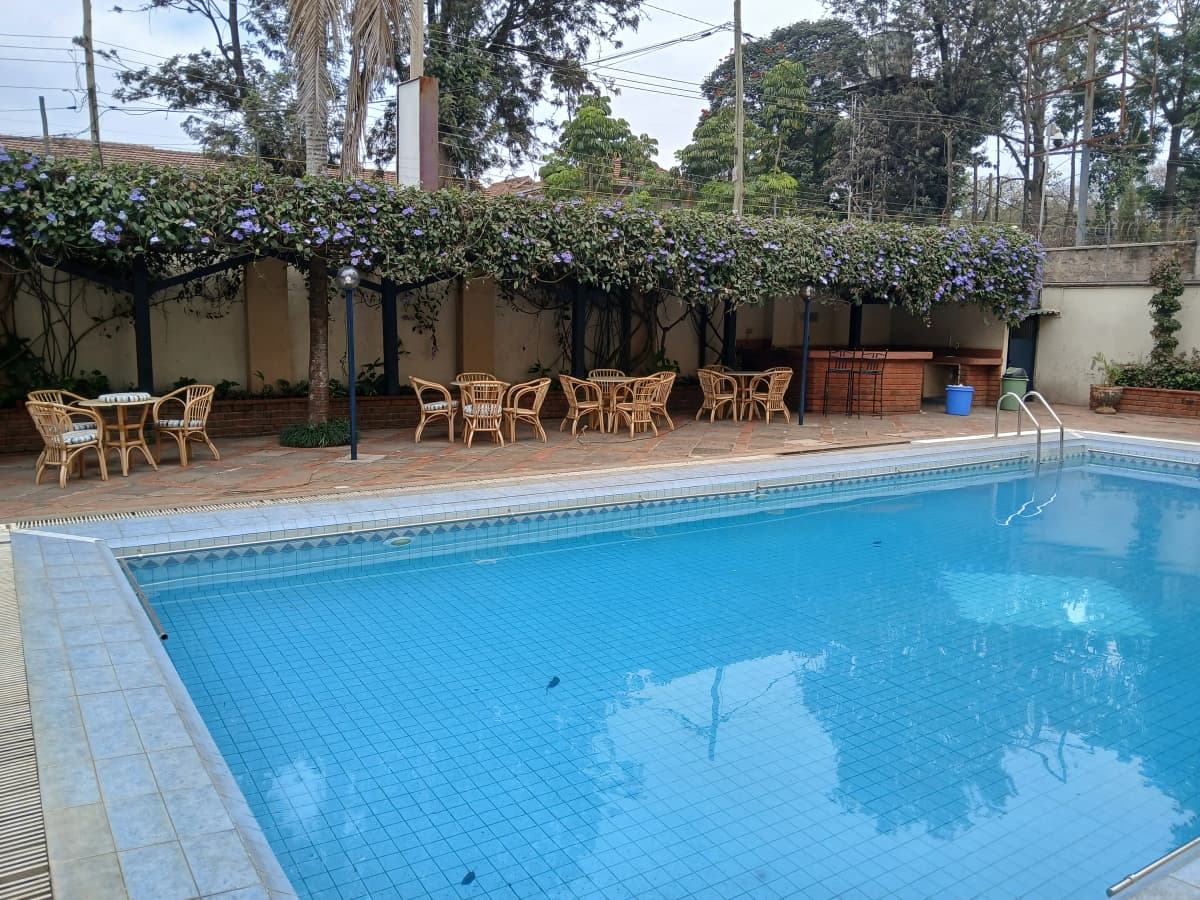 Large residential swimming pool with tiled deck and seating area