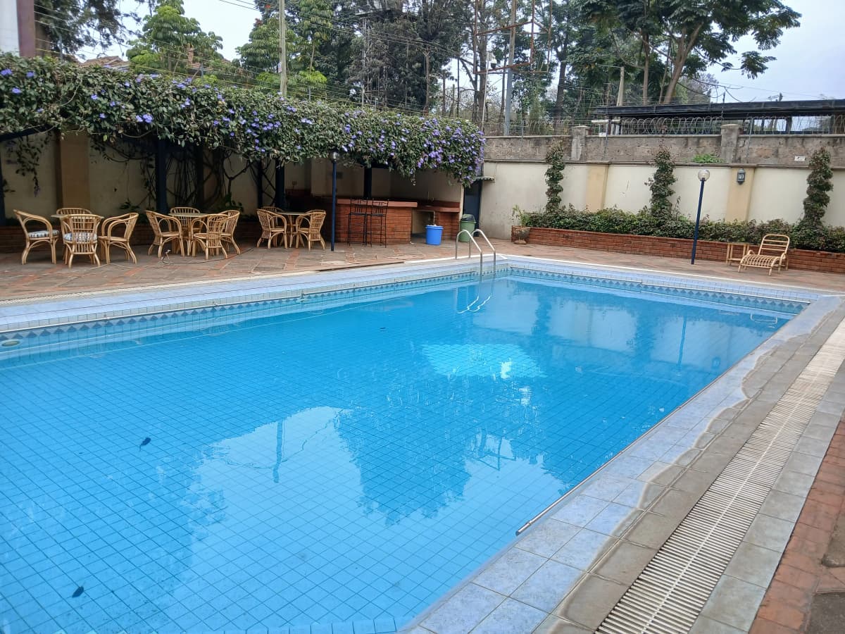 Rectangular swimming pool with lounging area and compound seating