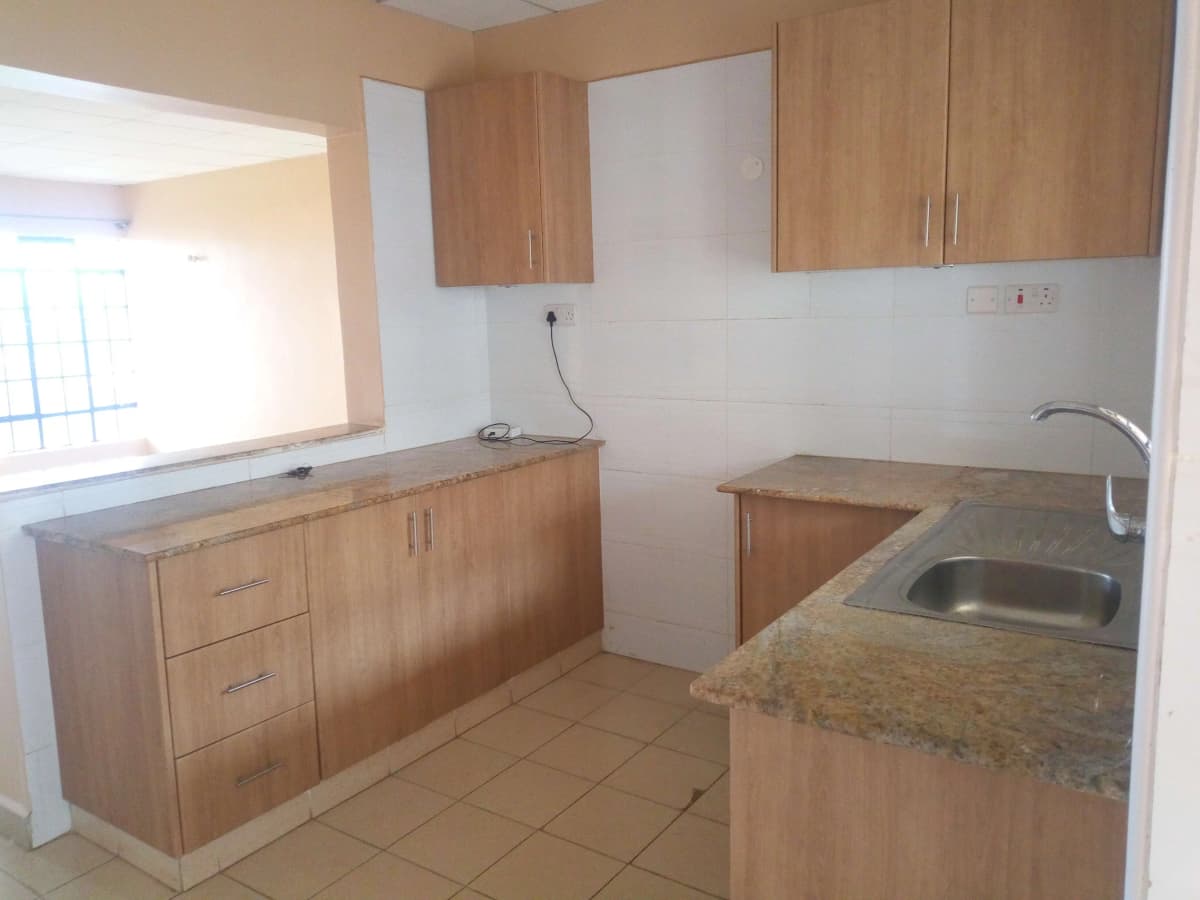 L-shaped kitchen with wooden cabinets and granite countertops