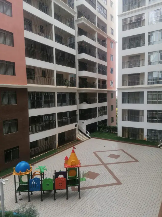 Compound courtyard with children's playground and paved grounds