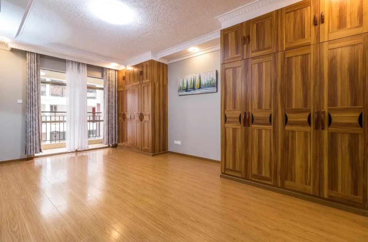 Spacious bedroom with wooden wardrobes and balcony access