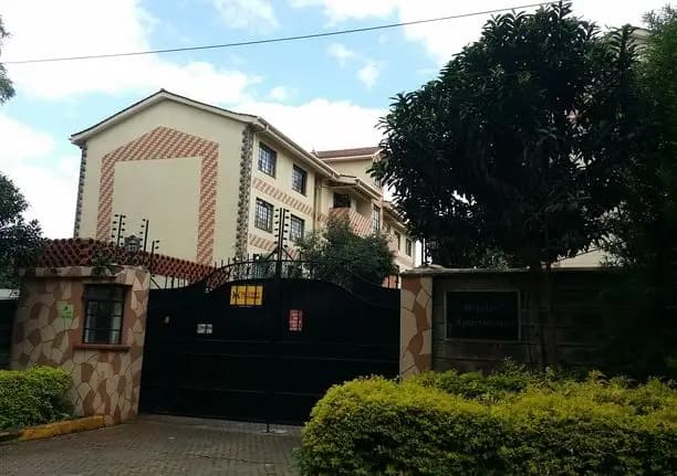 Multi-story residential building with black metal gate entrance