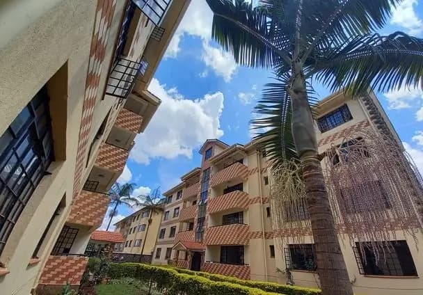 Multi-story residential building with brick facade and palm tree