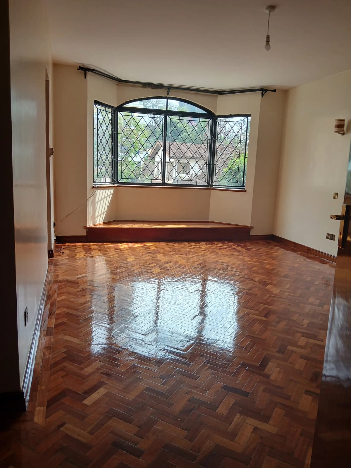 Spacious living room with herringbone parquet flooring and bay windows