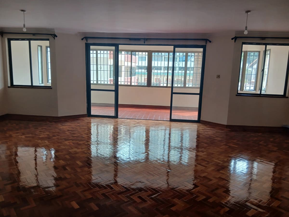 Spacious living room with herringbone wood floor and balcony access