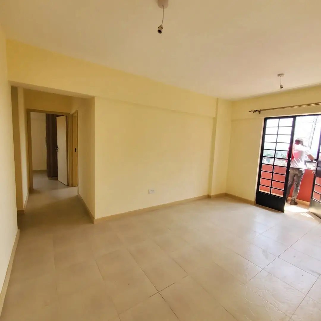 Spacious open-plan living area with yellow walls and balcony access