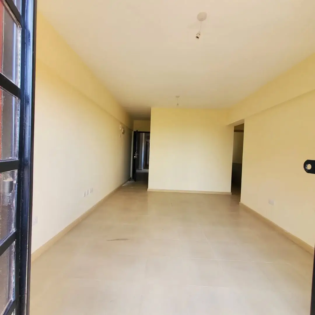 Spacious empty living room with yellow walls and polished floor