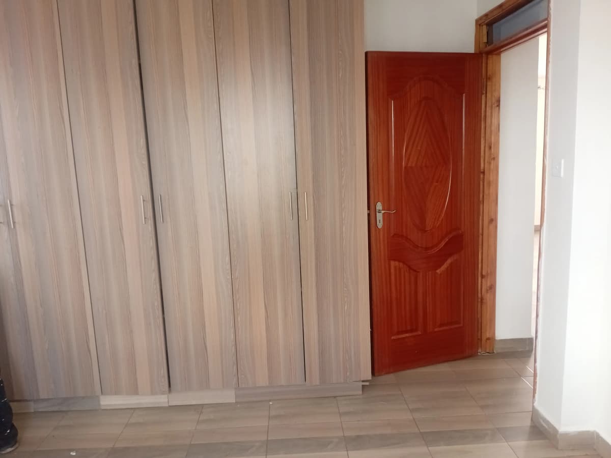 Bedroom with built-in wardrobes and red door entry