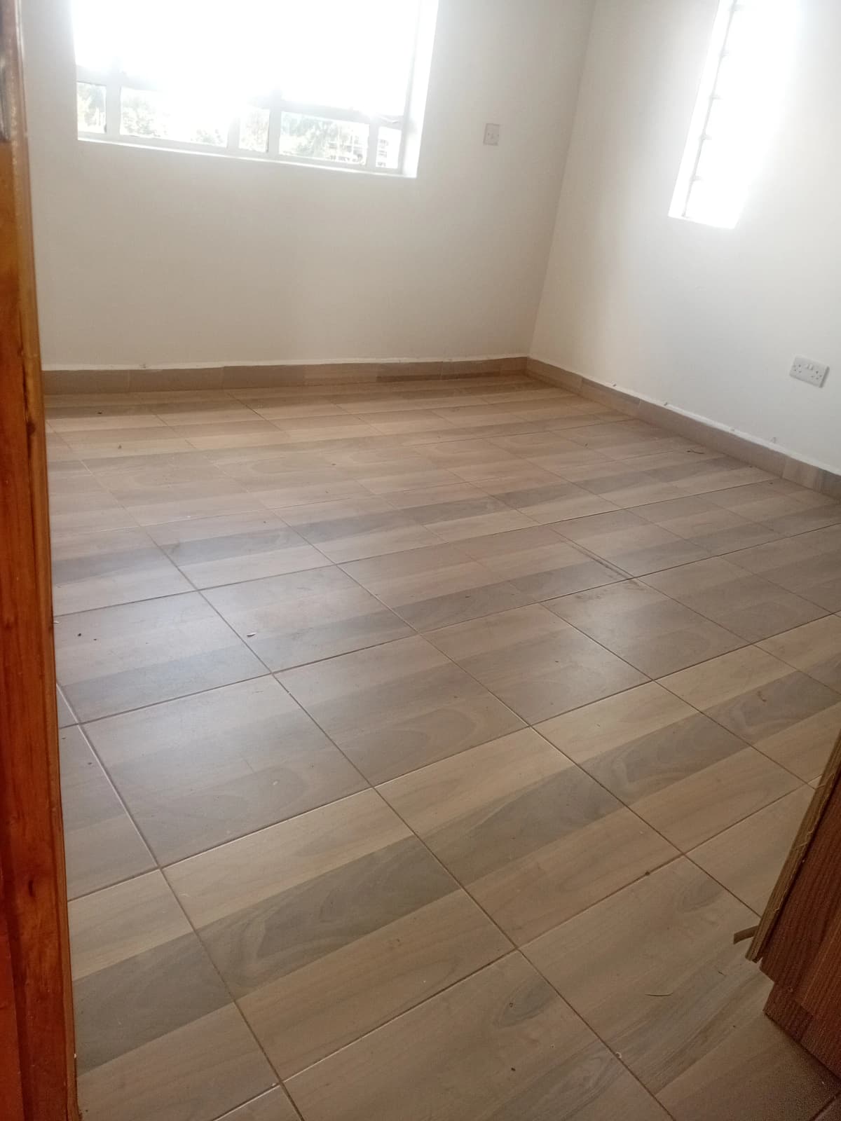 Spacious bedroom with ceramic tile flooring and natural light