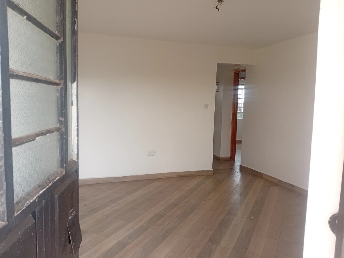 Bright empty living room with wooden flooring and natural light