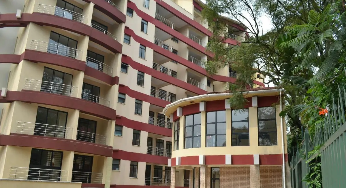 Modern multi-story apartment building with red and cream facade