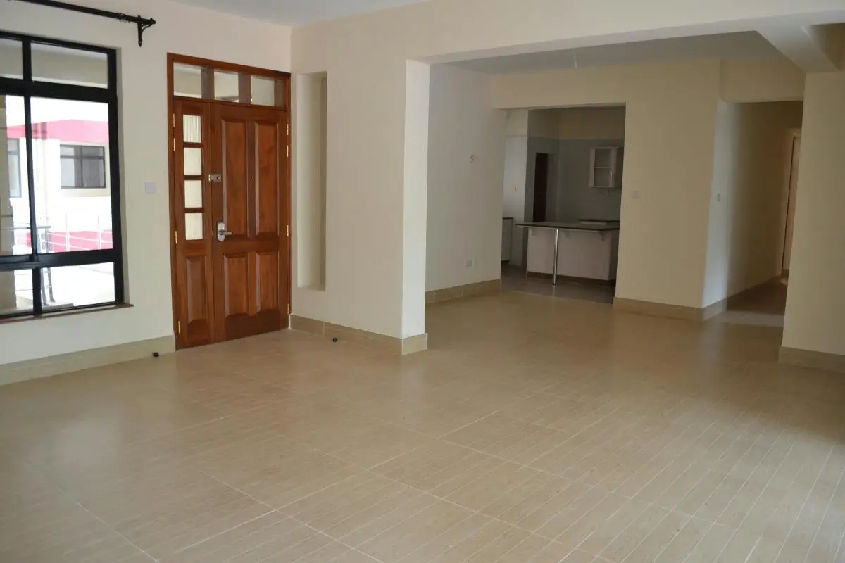 Open-plan living area with kitchen visible in background