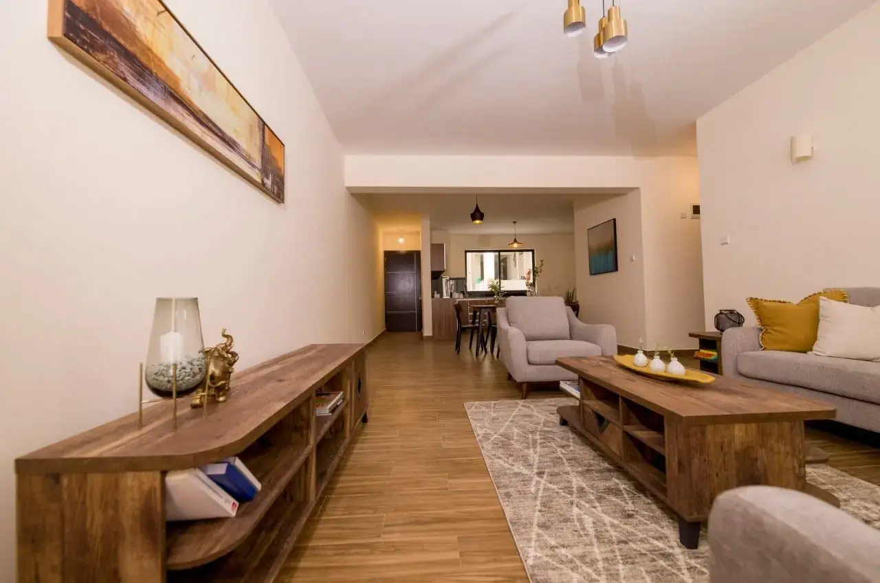 Open-plan living room with wooden furniture and dining area visible