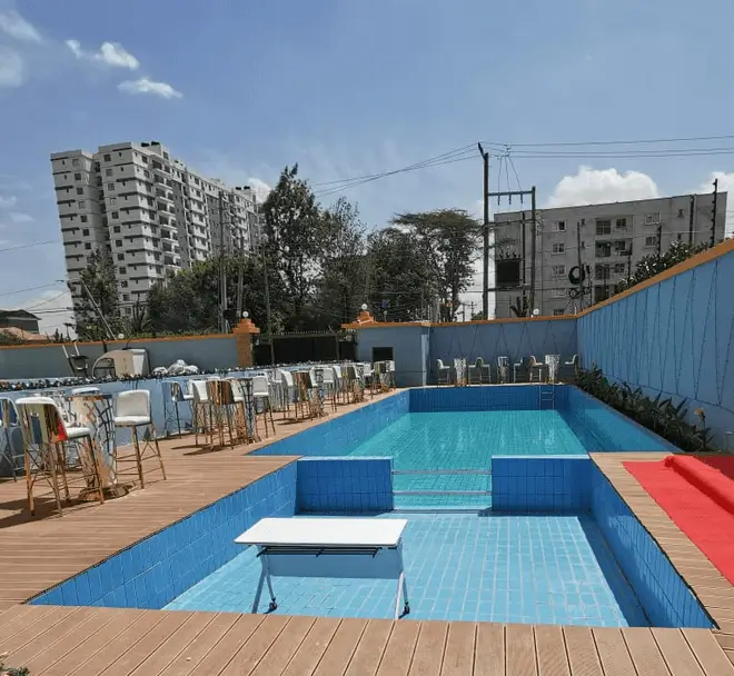 Swimming pool with blue lined interior and wooden deck surround
