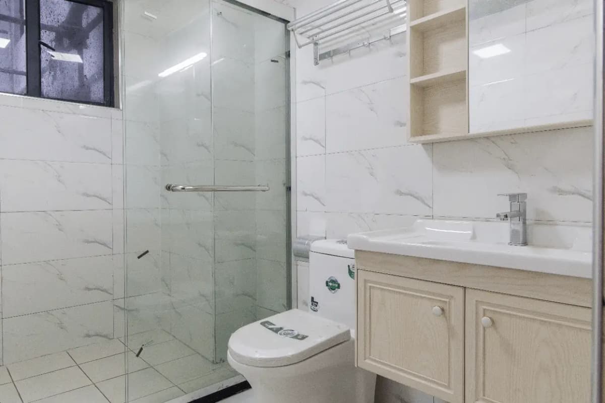 Modern bathroom with marble tiles, glass shower enclosure