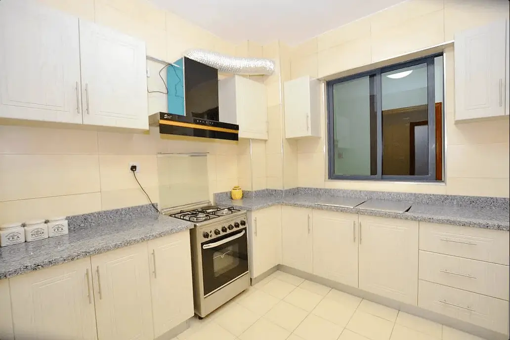 Modern kitchen with white cabinetry, granite countertops, gas stove