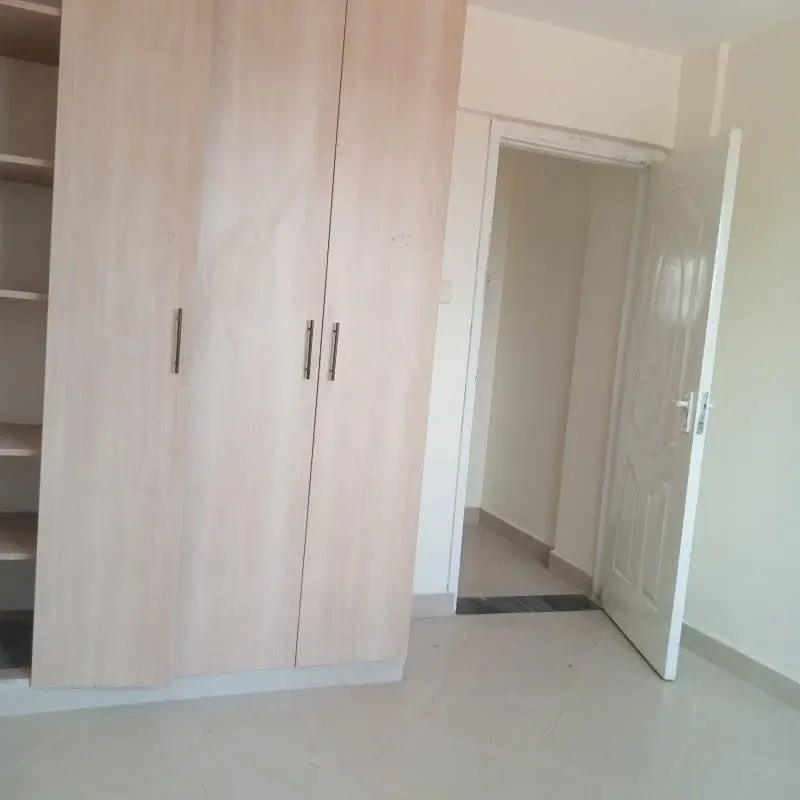 Bright bedroom with built-in wardrobe and open door