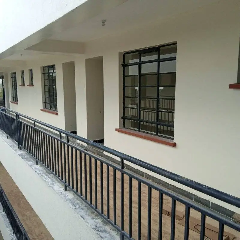 Covered balcony with metal railings and large windows