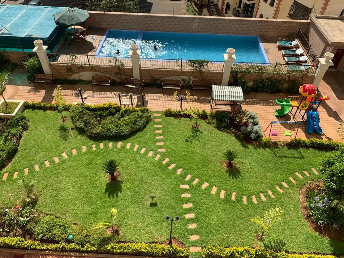 Aerial view of resort pool with landscaped gardens and playground
