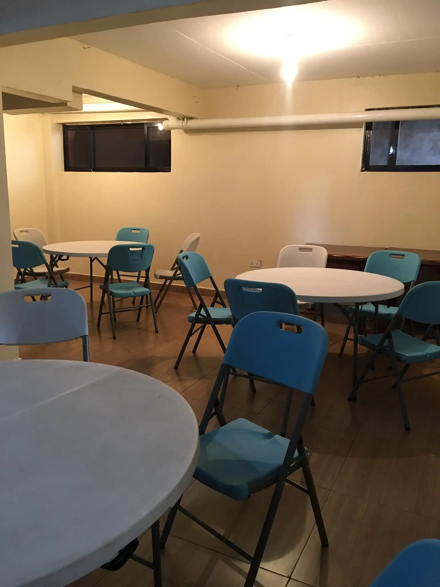 Common area with round tables and blue folding chairs