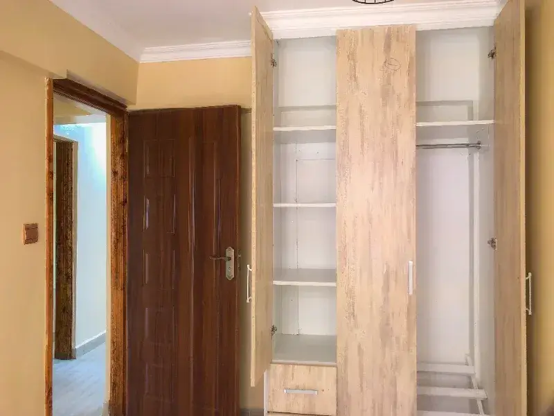 Bedroom with built-in wooden wardrobe and cream walls